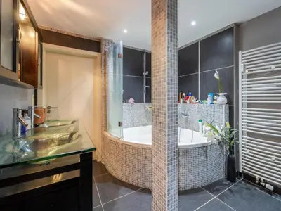 a bathroom with two sinks and a bath tub at Luxe Serene Residence in Brussels