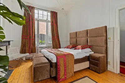 a bedroom with a large bed and a window at Le Papillon Antwerp Suite 3 in Antwerp