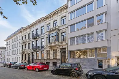 a large building with cars parked in front of it at Le Papillon Antwerp Suite 3 in Antwerp