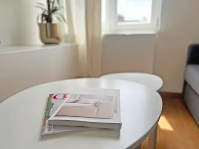 a magazine sitting on top of a white table at Astrid Sauna Appartement Antwerp in Antwerp