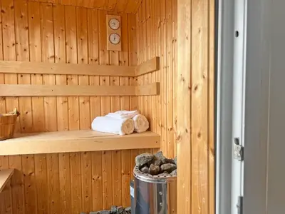 a wooden sauna with towels and a trash can at Astrid Sauna Appartement Antwerp in Antwerp