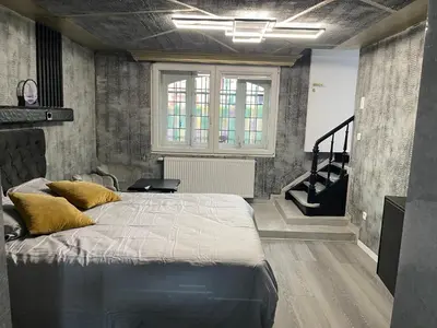 a bedroom with a large bed and a staircase at Jungle suite romantic - private Jacuzzi - in Brussels