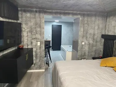 a bedroom with a bed and a desk and a bathroom at Jungle suite romantic - private Jacuzzi - in Brussels