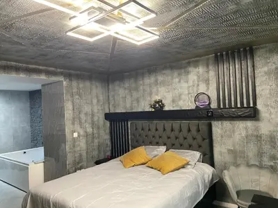 a bedroom with a bed with yellow pillows on it at Jungle suite romantic - private Jacuzzi - in Brussels