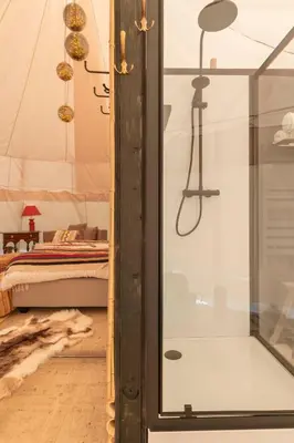 a bedroom with a tent with a bed and a glass door at Tipi Bo Deluxe in Kaprijke