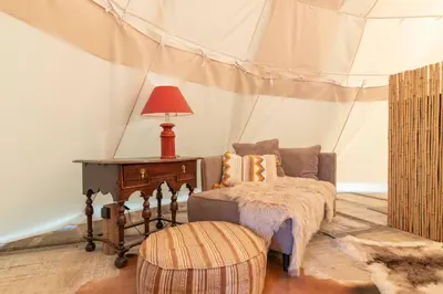 a room with a tent with a couch and a table at Tipi Bo Deluxe in Kaprijke