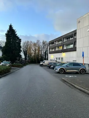 a parking lot with cars parked in front of a building at Atomium Brussels Expo Stay in Brussels