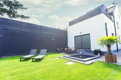 a backyard with chairs and a fence and a lawn at Luxurious Escape - Room LoveSerenity with pool and jacuzzi in Brussels