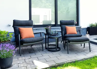 a patio with three chairs and a table and a table and some flowers at Luxurious Escape - Room LoveSerenity with pool and jacuzzi in Brussels
