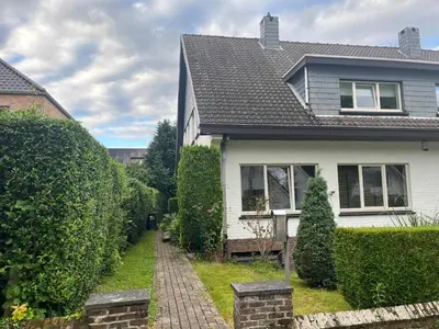 a white house with a pathway leading to a yard at Zonnebos in Kraainem
