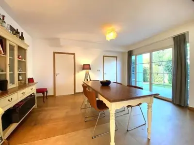 a living room with a table and chairs in a room at Zonnebos in Kraainem