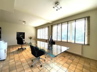 an office with a glass desk and two chairs at Zonnebos in Kraainem