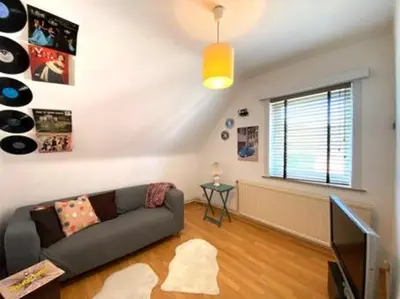 a living room with a couch and a television at Zonnebos in Kraainem