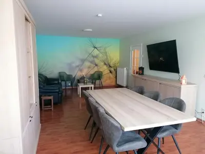 a dining room with a table and chairs and a tv at Antwerp horizon in Borsbeek