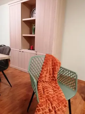 a chair with an orange blanket on it in a room at Antwerp horizon in Borsbeek