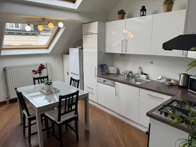 a kitchen with white cabinets and a table with chairs at Central Brussel - steps Grand Place - local vibrant neighbourhood in Brussels