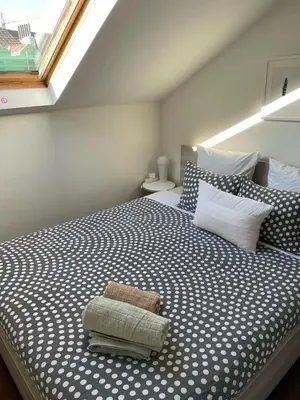 a bedroom with a large bed with a window at Central Brussel - steps Grand Place - local vibrant neighbourhood in Brussels