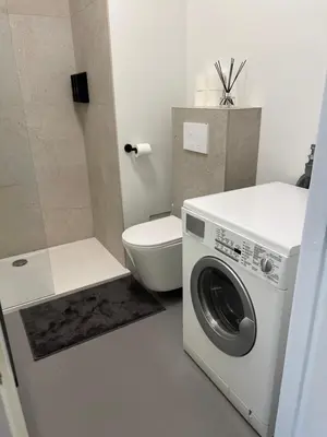 a bathroom with a washing machine and a toilet at Studio 59 in Antwerp