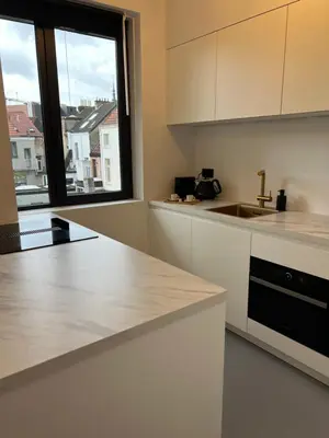 a kitchen with white counter tops and a window at Studio 59 in Antwerp