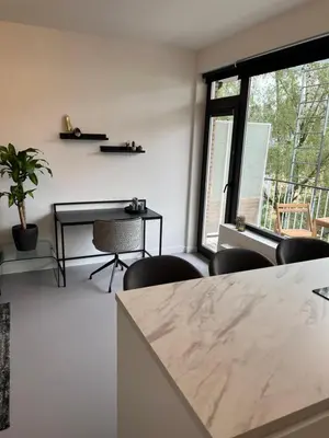 a living room with a table and chairs and a window at Studio 59 in Antwerp