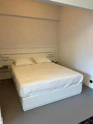 a bedroom with a white bed with white sheets and pillows at Studio 59 in Antwerp