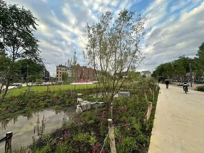 a person riding a bike in a park with flowers at cozy casa d'anvers op een unieke toplocatie in Antwerp