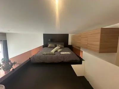 a bedroom with a bed in the corner of a room at cozy casa d'anvers op een unieke toplocatie in Antwerp