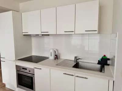 a kitchen with white cabinets and a sink at LUYS Apartment in Brussels
