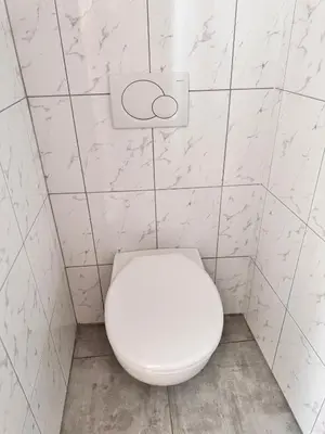 a white toilet in a bathroom with white tiles at LUYS Apartment in Brussels