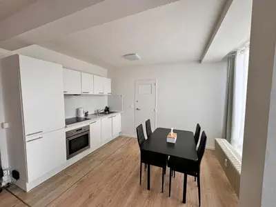 a kitchen and dining room with a black table and chairs at LUYS Apartment in Brussels