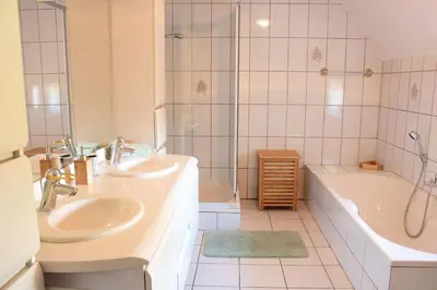 a bathroom with two sinks and a tub and a shower at Doornhof, rustig gelegen vakantiehuis in Haaltert