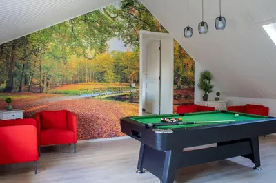 a room with a pool table and a forest mural at Doornhof, rustig gelegen vakantiehuis in Haaltert