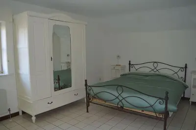 a bedroom with a bed and a dresser and a mirror at Doornhof, rustig gelegen vakantiehuis in Haaltert