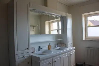 a bathroom with two sinks and a large mirror at Doornhof, rustig gelegen vakantiehuis in Haaltert