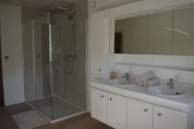 a bathroom with two sinks and a glass shower at Doornhof, rustig gelegen vakantiehuis in Haaltert
