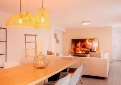 a living room with a table and a fireplace at Calya Family Home in Brussels - 4 Bedrooms in Sint-Pieters-Leeuw