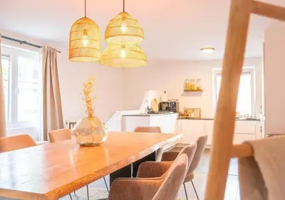 a dining room with a wooden table and chairs at Calya Family Home in Brussels - 4 Bedrooms in Sint-Pieters-Leeuw