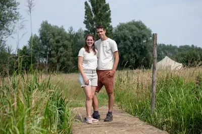 a man and a woman standing on a path at Rosephine Glamping in Lievegem