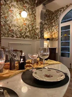 a table with wine glasses and a plate on it at La Petite Foret Art Deco Apartment in Brussels in Brussels