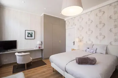 a bedroom with a bed and a desk and a television at Restaurant & Guesthouse Cachet de Cire in Turnhout