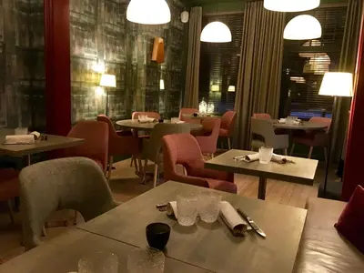 a dining room with tables and chairs and lights at Restaurant & Guesthouse Cachet de Cire in Turnhout