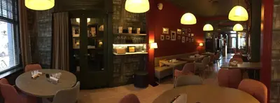 a restaurant with tables and chairs in a room at Restaurant & Guesthouse Cachet de Cire in Turnhout