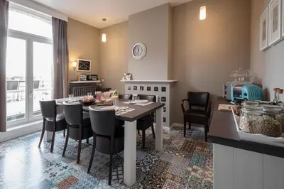 a kitchen with a table and chairs in a kitchen at Restaurant & Guesthouse Cachet de Cire in Turnhout