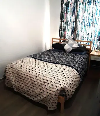 a bedroom with a bed with a black and white comforter at Appartement cozy à Saint-Gilles in Brussels
