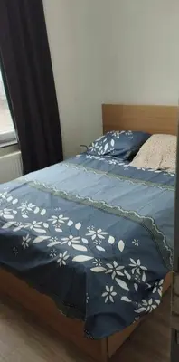 a bed with a blue blanket with white flowers on it at Appartement cozy à Saint-Gilles in Brussels