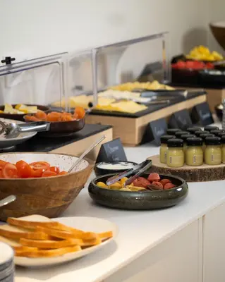 a buffet with plates of food on a table at The Liman Hotel in Brussels