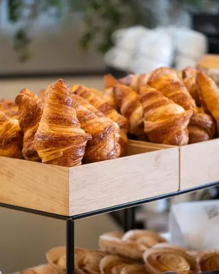 a bunch of pastries on display in a bakery at The Liman Hotel in Brussels