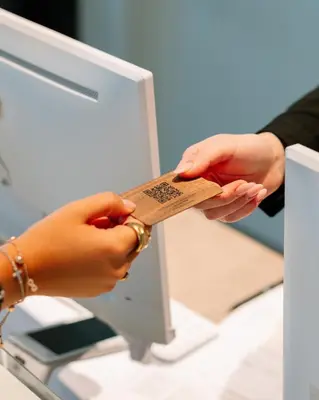 a person holding a piece of paper in front of a computer at The Liman Hotel in Brussels