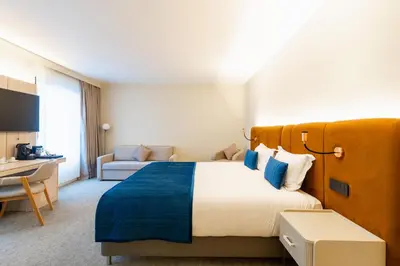 a hotel room with a large bed and a couch at The Liman Hotel in Brussels