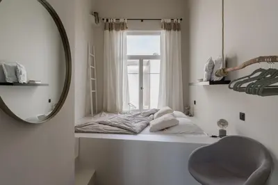 a bathroom with a mirror and a bed in a window at Mooi licht appartement in bruisend Antwerpen! in Antwerp